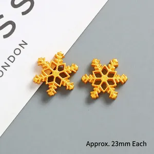 Detailed view of 23mm golden snowflake charms with hollow hexagonal design for DIY crafts