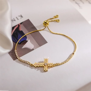 Detail of adjustable gold-toned cross bracelet with sparkling zircon stones