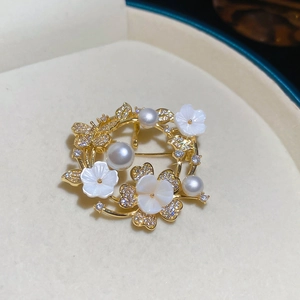 Detailed macro view of 18k gold-plated floral brooch with pearls and zircon in a velvet box