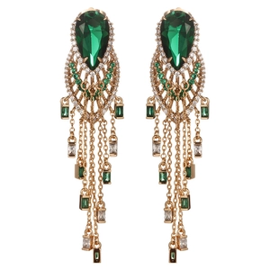 Detailed view of emerald drop earrings with gold chains and sparkling crystals