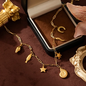 Golden stainless steel beach necklace with sea turtle and shell charms in a luxury box