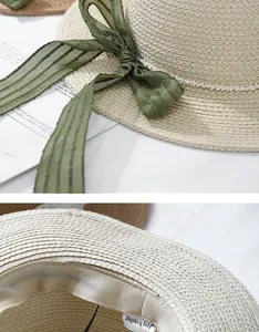 Detail of children's straw hat with green mesh bow, pearl strap, and inner sweatband