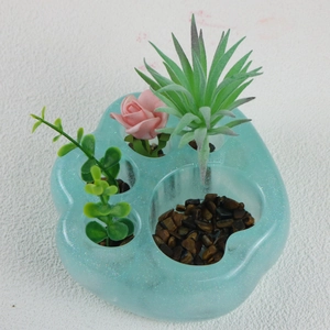 Vista superior de maceta de resina de garra de gato azul brillante con mini plantas