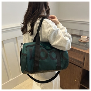 Green duffel bag with black straps and LOOK lettering shown carried by a model