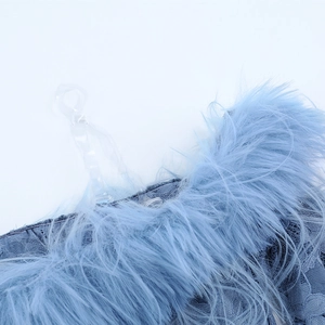 Detailed close-up of light blue lace fabric with soft faux fur trim and clear straps