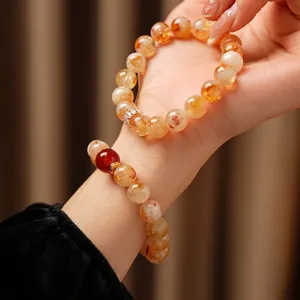 Bracelet élégant en citrine avec accents d'agate rouge sur un fond de tissu chaleureux