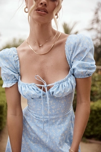 Detail of light blue floral dress with puff sleeves and lace-up front knot design