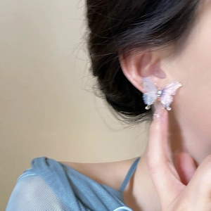Vue détaillée des boucles d'oreilles papillon avec dégradé violet et petits diamants