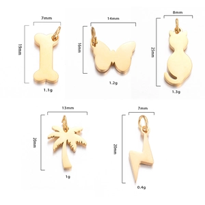 Detailed view of polished gold stainless steel pendants in cat, butterfly and bone shapes