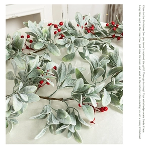 Detail of flocked leaves and red berries for festive Christmas table decor and mantel ornament