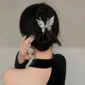 Silver liquid metal butterfly hair claw clip with intricate wing texture on model hair