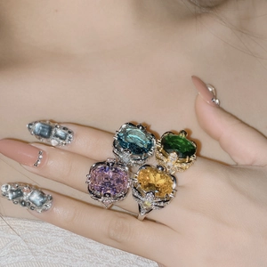 Close-up of luxury 18k plated rings with large colorful gemstones and diamond accents