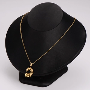Golden wheat leaf pendant necklace set displayed on a professional black jewelry mannequin