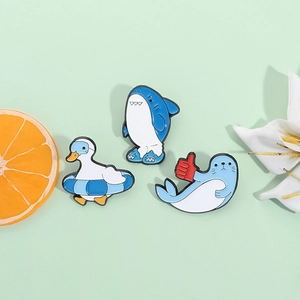 Cute shark, duck, and seal enamel pins set on a decorative mint green background