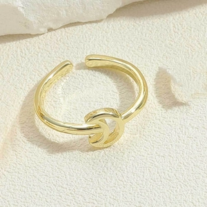 Macro shot of gold adjustable crescent ring showcasing polished metal texture and finish