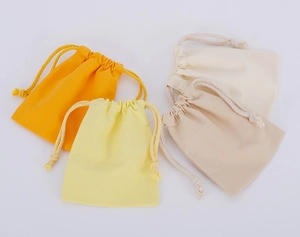 Detailed view of small cotton drawstring jewelry pouches in four pastel color tones
