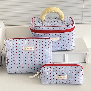 Three quilted blue makeup bags with red hearts featuring yellow top handle and embroidery