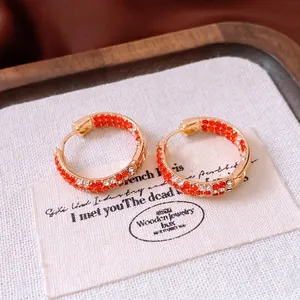 Élégantes boucles d'oreilles créoles dorées avec cristaux rouges et transparents