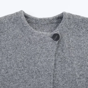 Gros plan d'un manteau en laine grise double face avec col rond et boutons classiques