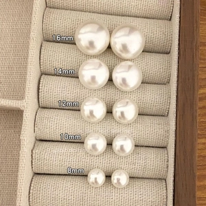 Flat round pearl stud earrings set for women in 8mm to 16mm sizes shown in a jewelry box