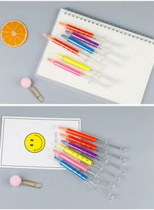 Detail of syringe shaped highlighters in six colors on a notebook with lemon prop