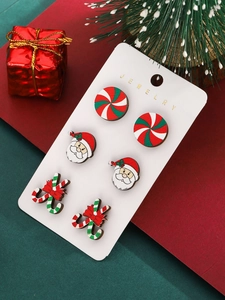 Macro detail of Christmas stud earrings set with Santa and candy canes on card