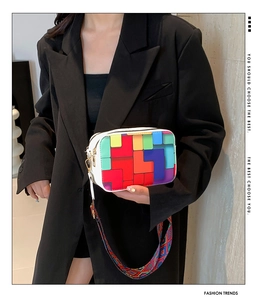 Detail of colorful geometric patchwork square bag with wide textured shoulder strap