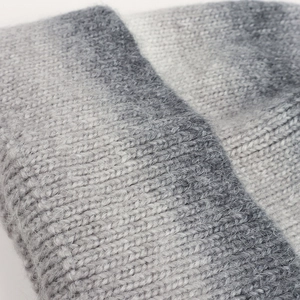 Close-up of grey and white tie-dye knit beanie showing fuzzy wool texture and detail