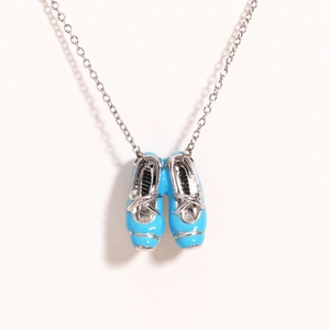 Detailed shot of blue enamel ballet slippers pendant on a delicate metal chain