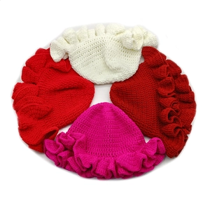 Detailed knit texture and multi-layered ruffled edges on handmade baby hats