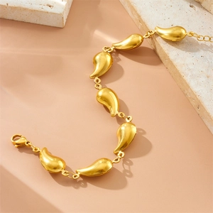 Elegant 18K gold plated stainless steel teardrop link bracelet on a stone pedestal