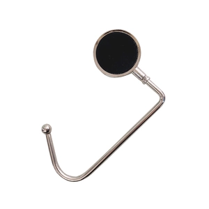 Close-up of portable silver folding bag hook with a black circular decorative top detail