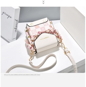 Detail view of mini plaid phone bag with pink scarf handle and gold hardware detail