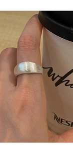 Macro shot of minimalist S925 sterling silver wide band ring with a brushed matte finish