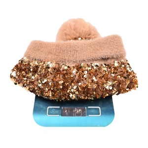 Brown knit beanie with gold sequins and pompom weighing 128g on a digital scale