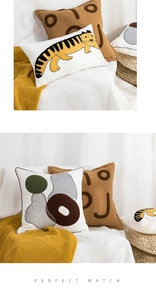 Detail of towel embroidered cushion covers featuring tiger and abstract geometric patterns