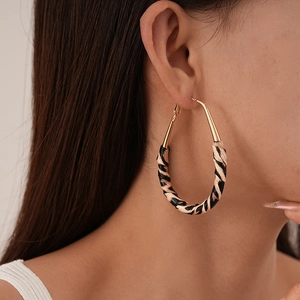 Gros plan de la boucle d'oreille créole léopard en similicuir portée par un mannequin