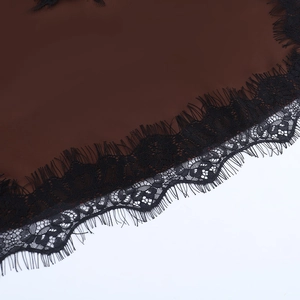 Vue macro détaillée d'un tissu marron foncé avec bordure en dentelle noire fine