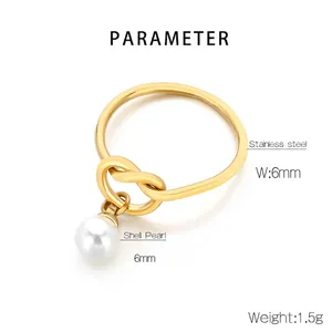Macro detail of gold stainless steel knot ring featuring a 6mm white shell pearl drop