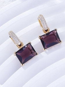Detail of purple rectangular gemstone earrings with gold hooks and micro-pave zircons