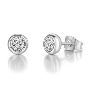 Macro shot of polished round bezel-set zircon stud earrings with silver metal and butterfly back
