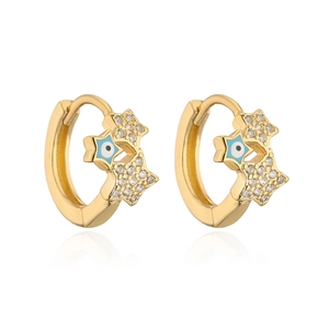 Detailed macro of gold-plated huggie earrings with zircon stars and blue evil eye charms