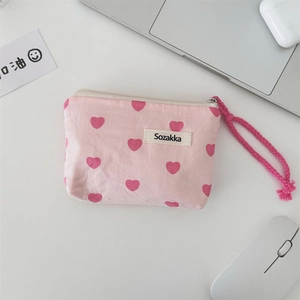 Detailed view of pink canvas heart storage pouch with zipper and woven carry strap