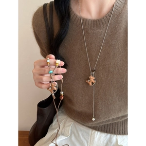 Long necklace with wooden rocking horse pendant, pearls and colorful beads on model
