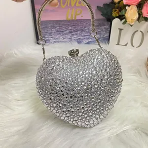 Macro view of heart-shaped evening bag with silver rhinestones and metal ring handle
