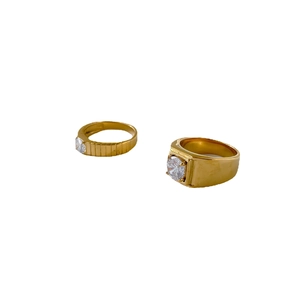 Golden couple rings with gear design and sparkling crystals on a clean white background