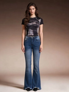Women's vintage print t-shirt and blue flared jeans with frayed hem in full-body shot
