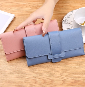 Detailed close-up of pink and blue long trifold wallets in lychee grain leather finish