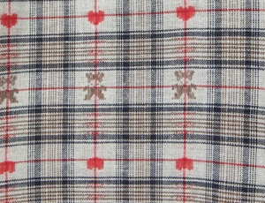 Detailed macro view of the plaid fabric featuring red hearts and brown bear patterns