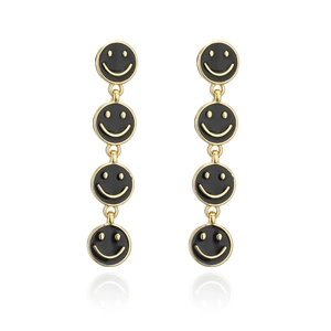 Detail of long drop earrings featuring four black enamel smiley faces and gold metal links